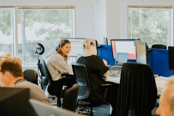 Two members of the Truespeed team laughing in the office